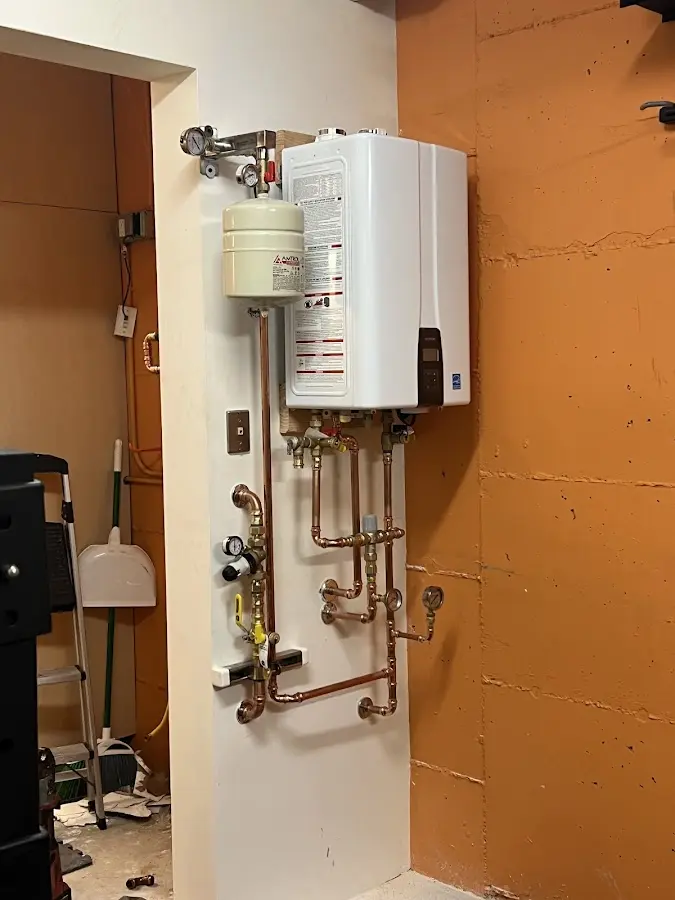 Plumbing technician inspecting water heater connections in South Milwaukee